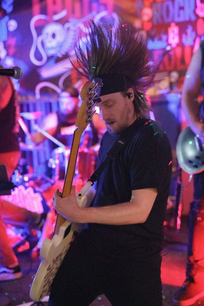 Laces Out bassist mid-headbang with hair flying during a live set