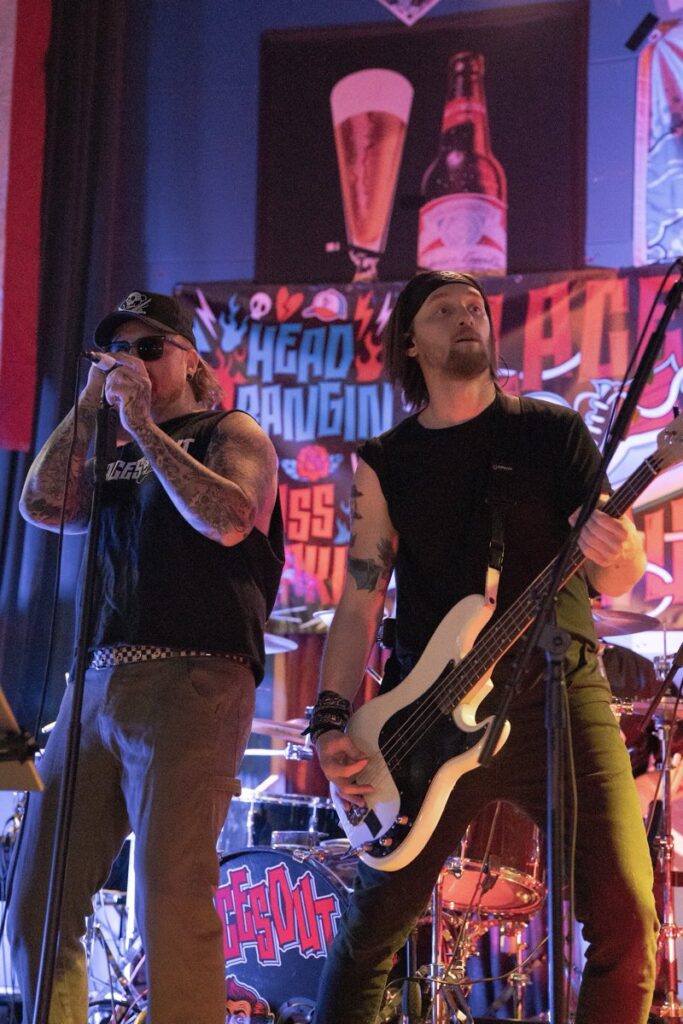 Laces Out singer and bassist performing side by side at the front of the stage