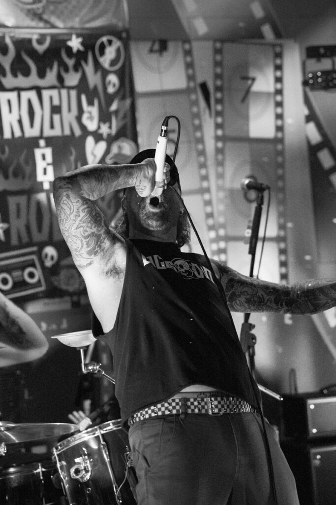 Black and white shot of the Laces Out singer holding the mic overhead